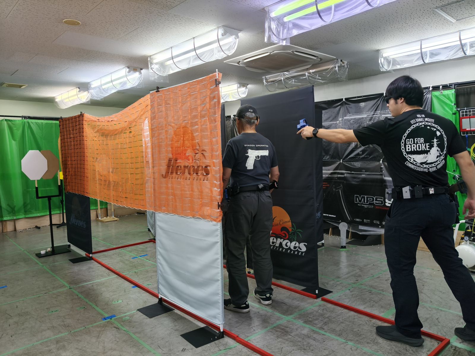 ステージでハンドガンを構えるメンバー